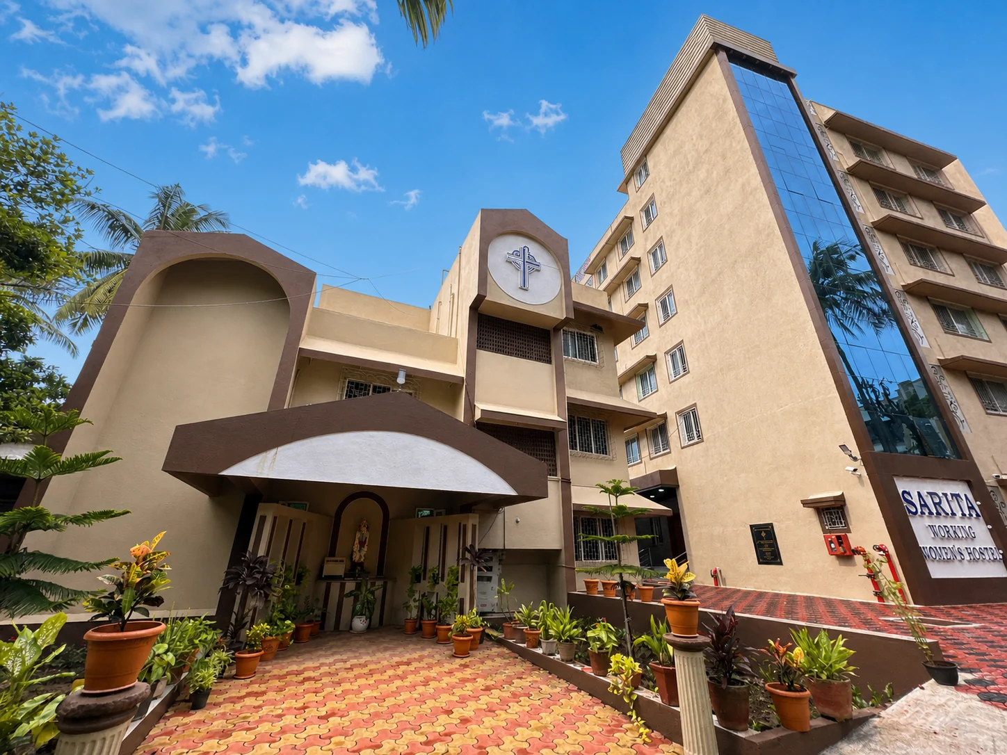 The green courtyard and hostel building at Sarita Working Women’s Hostel